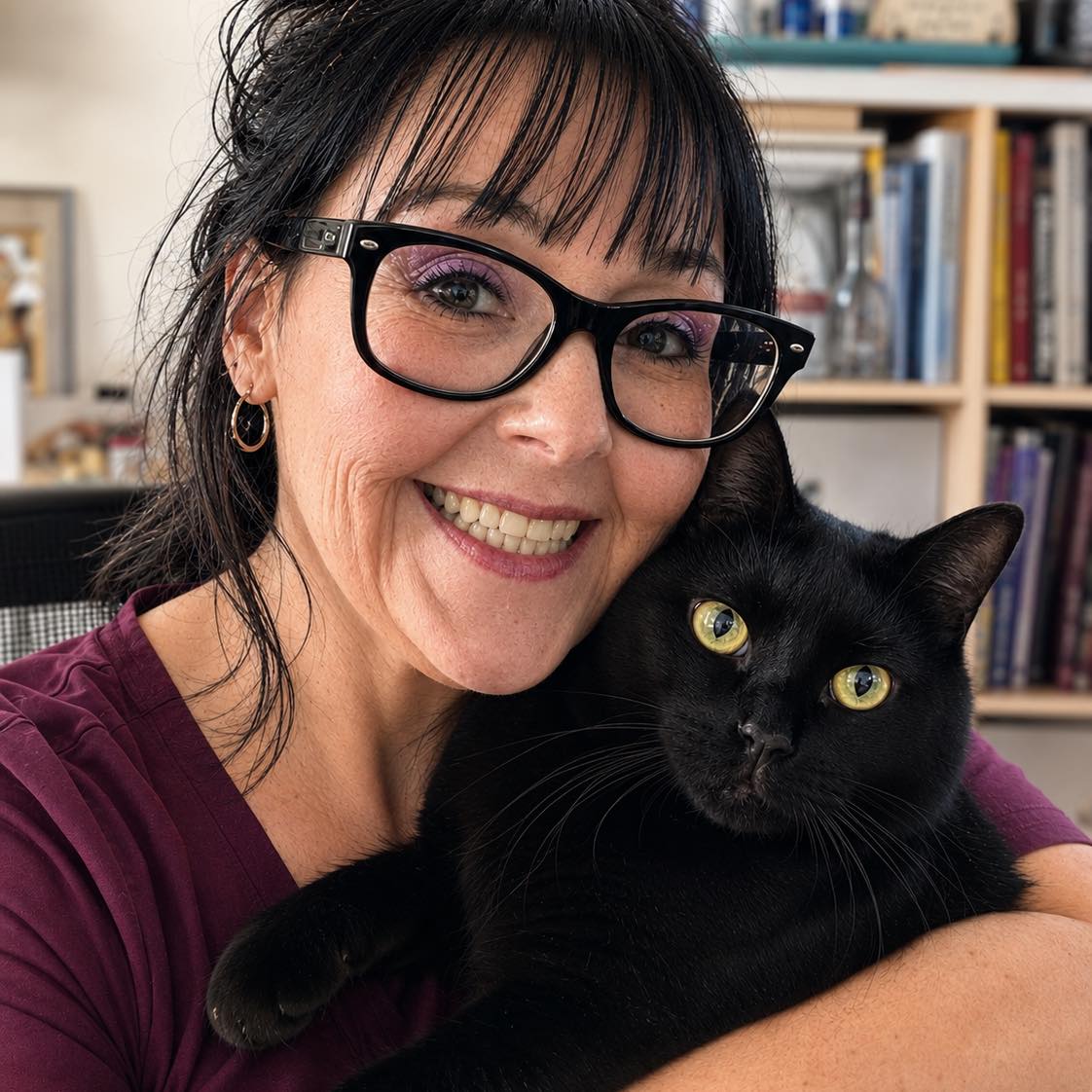 Tania Brown smiling while holding her black cat